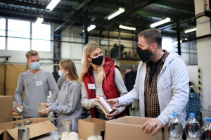 Group of volunteers in community charity donation center, food bank and coronavirus concept.