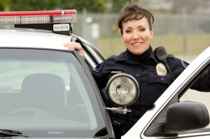 18565126_M - a friendly and smiling hispanic female officer with her patrol car.