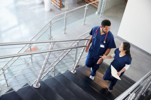 Two healthcare colleagues talking on the stairs at hospital