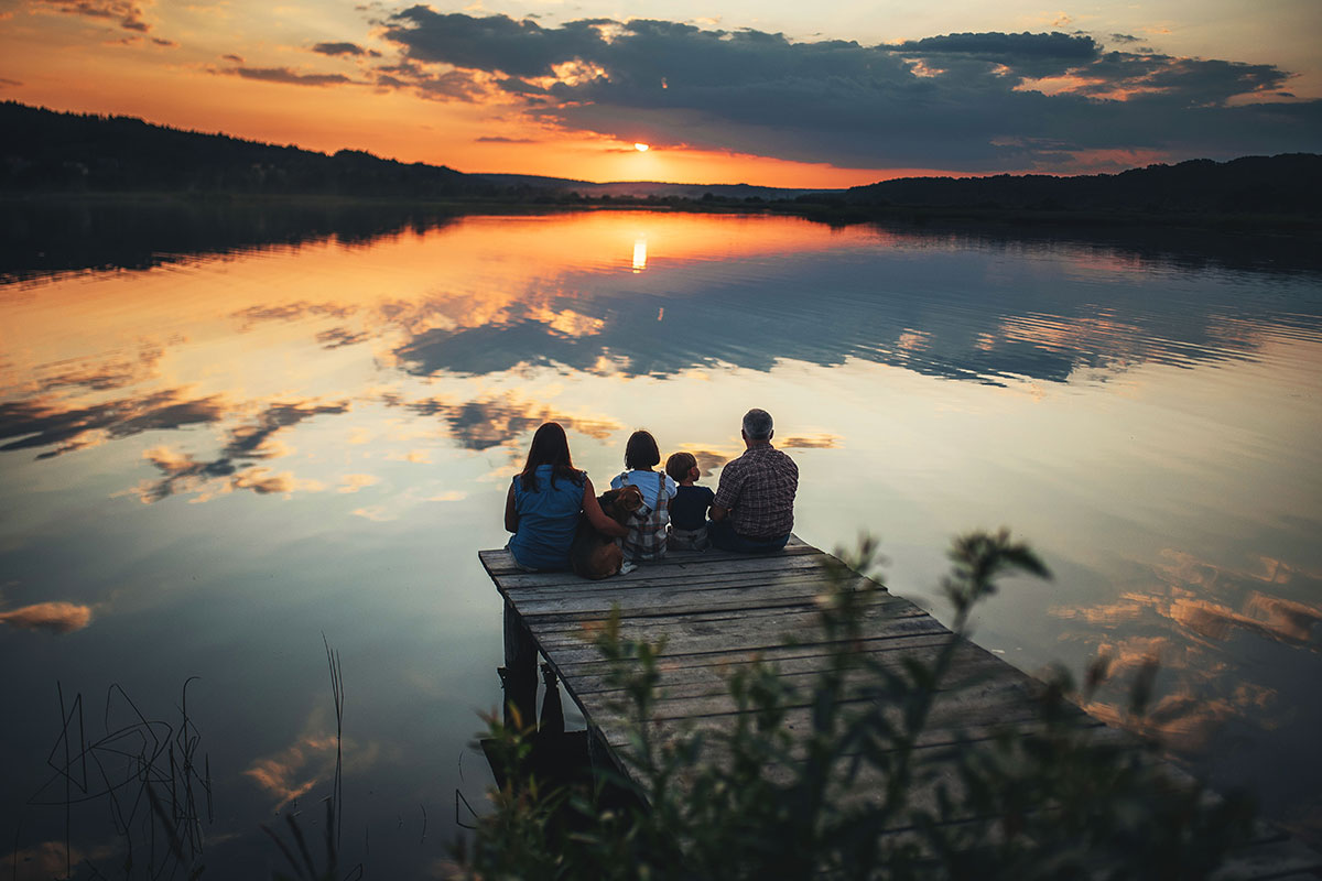 Family of four on a dock at sunset