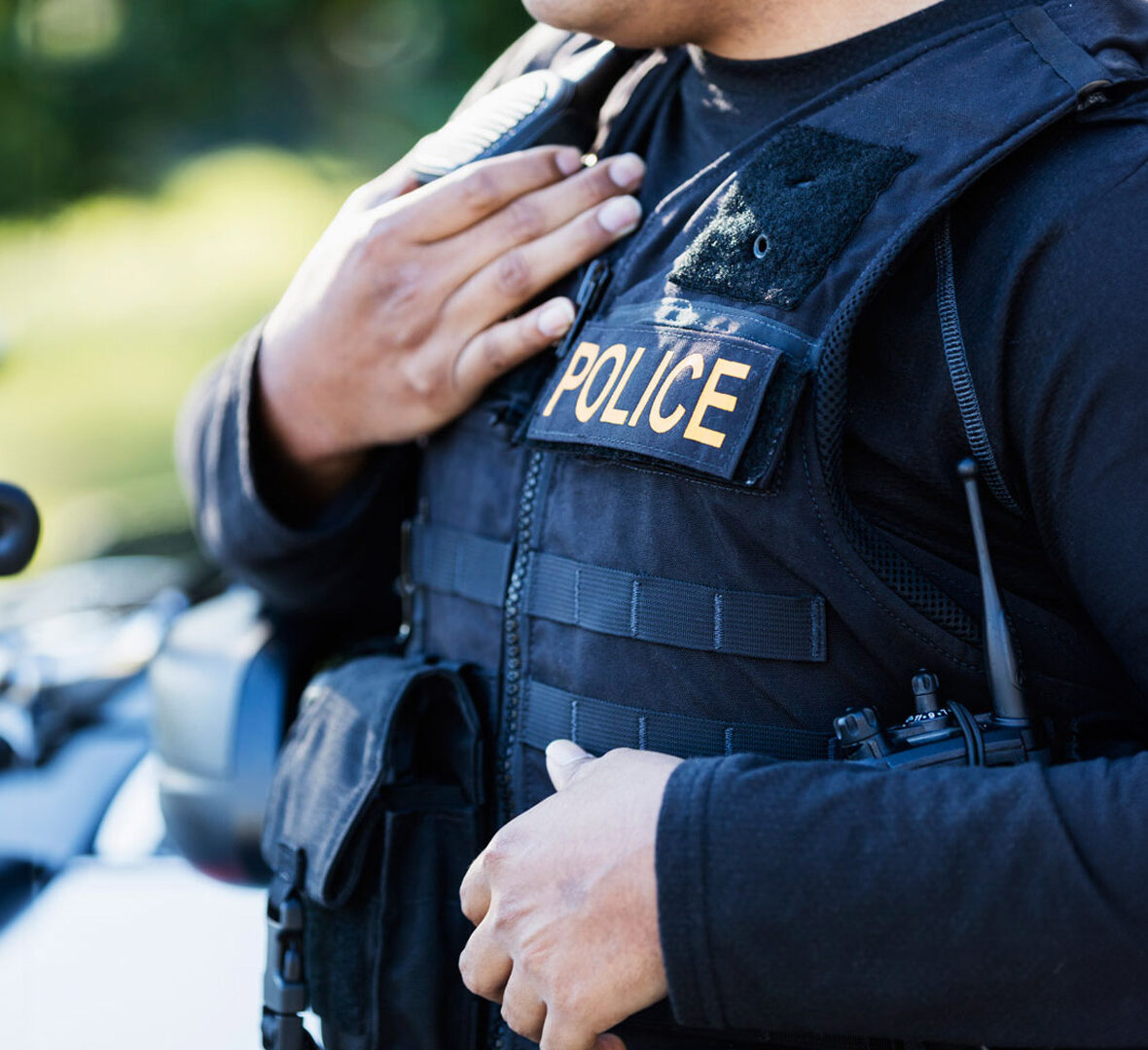 A law enforcement officer confidently stands on a motorcycle, ready to ensure public safety.