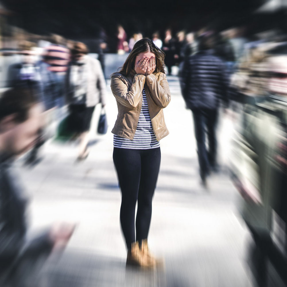 Off-duty nurse experiencing an anxiety attack on a busy sidewalk due to unresolved trauma, highlighting the importance of anxiety treatment centers like Deer Hollow for healing first responders and veterans.