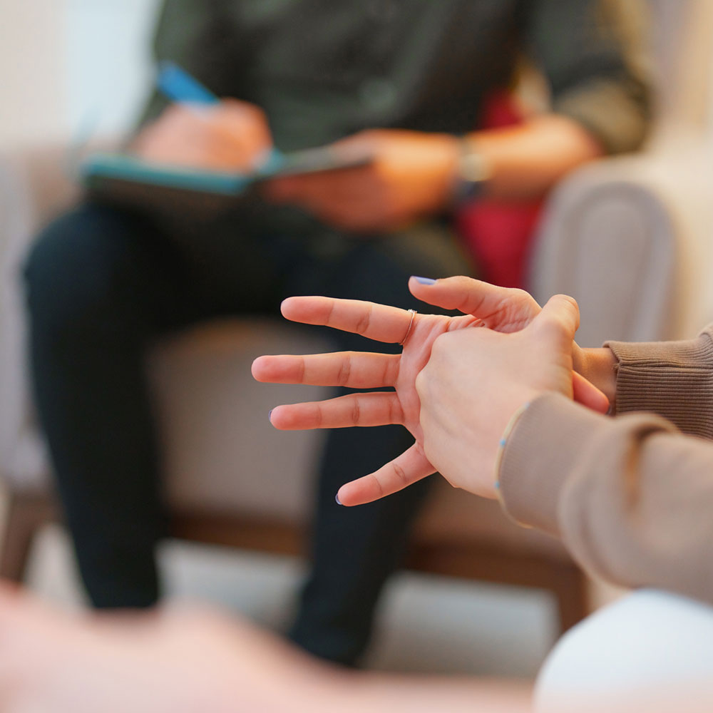 First Responder sitting with hands folded, intently listening to a therapist, highlighting the personalized care offered at Deer Hollow’s residential treatment centers and intensive outpatient programs.