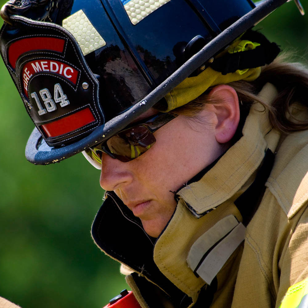 Traumatized female firefighter standing in distress after responding to a fatal automobile accident.