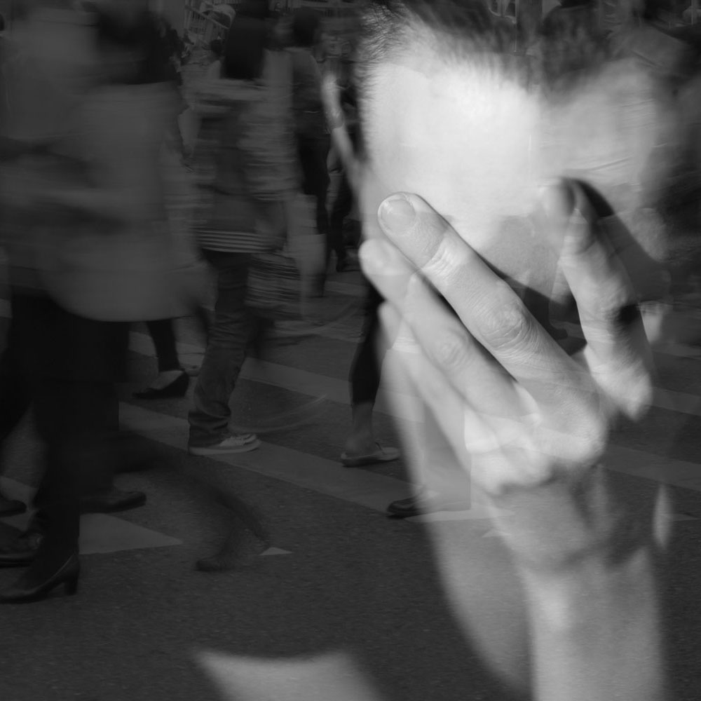 Crying nurse with hand over face struggling to control racing thoughts caused by unresolved trauma and mental health challenges; emphasizing the need for specialized mental health treatment at Deer Hollow.