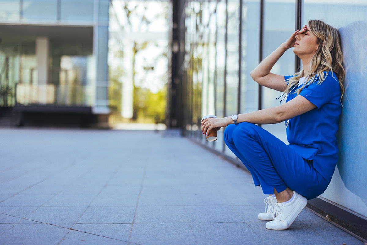 Depressed nurse feeling overwhelming guilt after the death of a child patient, emphasizing the mental health challenges faced by first responders and the specialized PTSD and addiction treatment programs offered at Deer Hollow's wellness center.